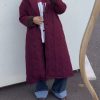 Manteau long matelassé noir à col contrastant bordeaux